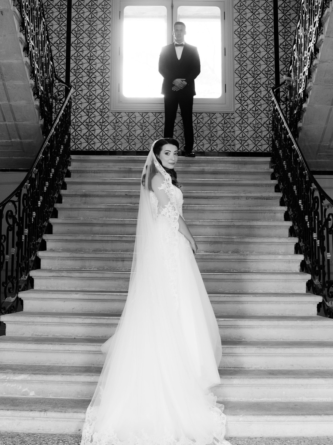 Mariée sur un grand escalier de château, noir et blanc